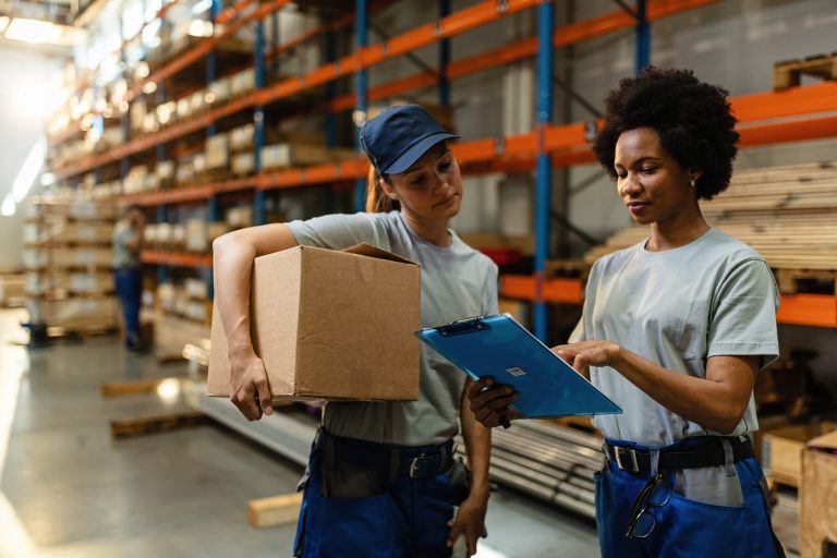 Female warehouse workers going through shipment list before the delivery